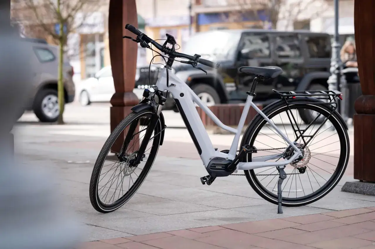 Szary rower elektryczny na chodniku, gotowy do jazdy po mieście. Dowiedz się, jak jeździć rowerem po mieście, by odkrywać nowe miejsca.