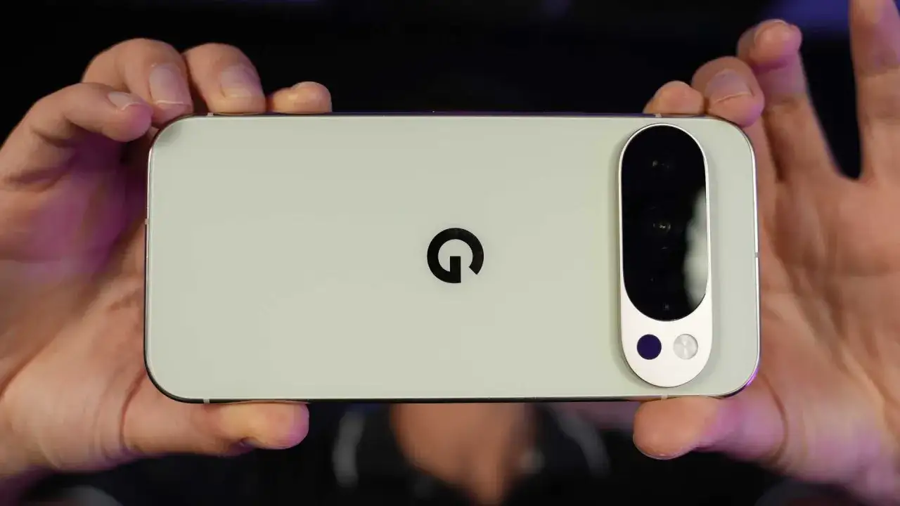 Gros plan sur le dos d'un smartphone Google Pixel vert pâle, tenu par deux mains.