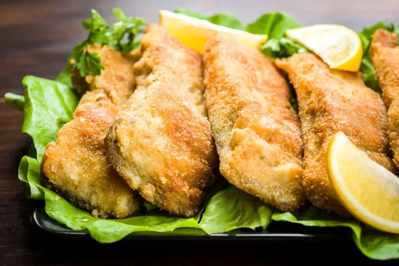 Chrupiące, złociste filety rybne na sałacie z cytryną. Idealne, gdy wiesz, jak smażyć ryby mrożone.