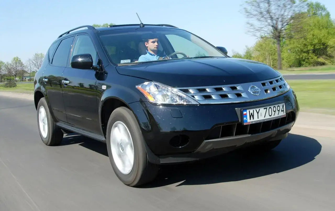 Czarny Nissan Murano 3.5 V6 w ruchu, za kierownicą siedzi mężczyzna.