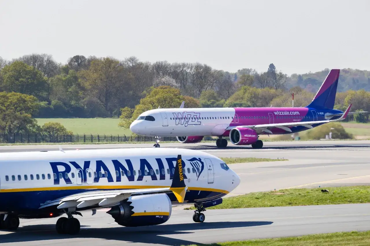 Samolot Ryanair na pierwszym planie, w tle samolot Wizz Air na pasie startowym.