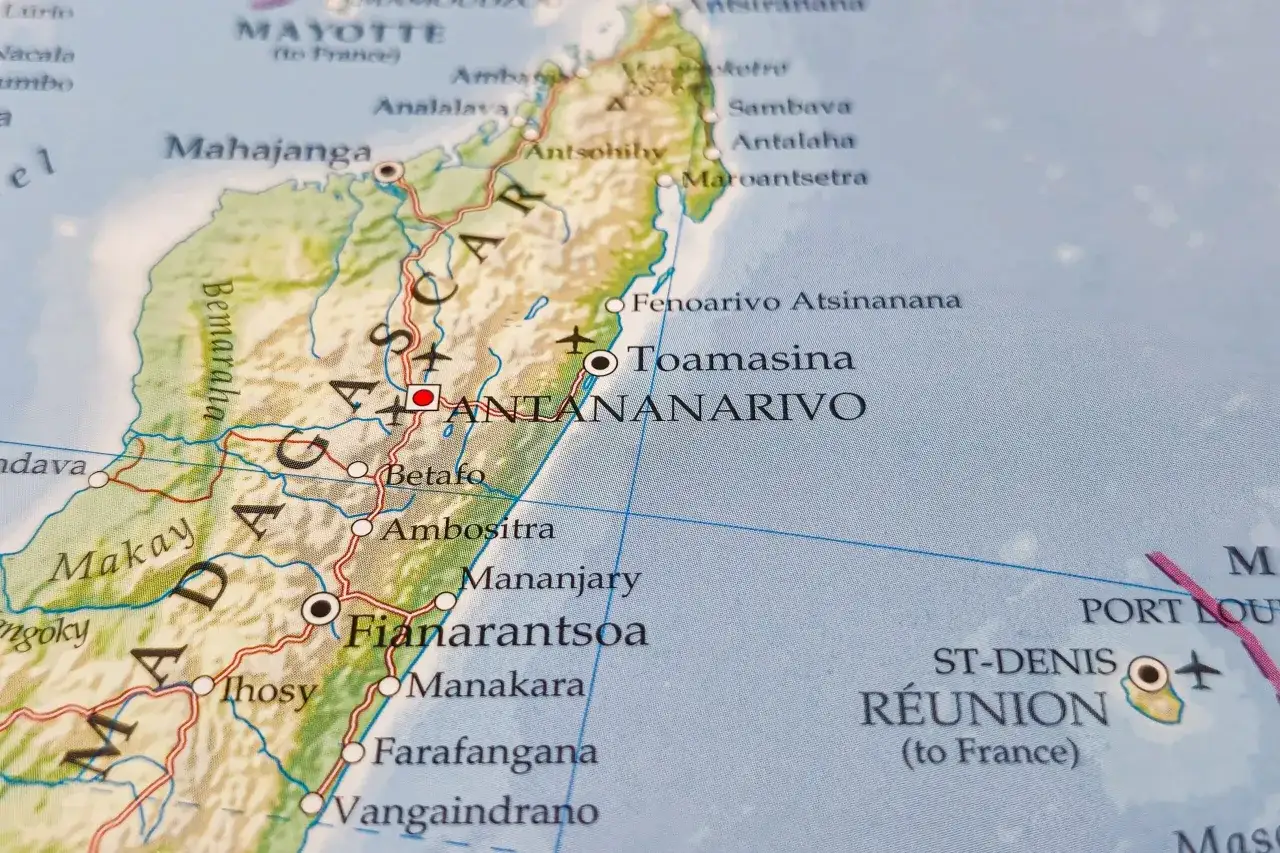 Mapa pokazuje, gdzie leży Madagaskar, z zaznaczonymi miastami jak Antananarywo i Fianarantsoa. Widać też wyspę Reunion.