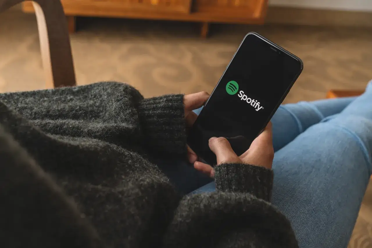 Osoba trzymająca telefon z otwartą aplikacją Spotify.