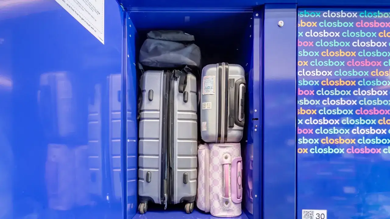 Luggage stored in a blue locker, including suitcases and bags.