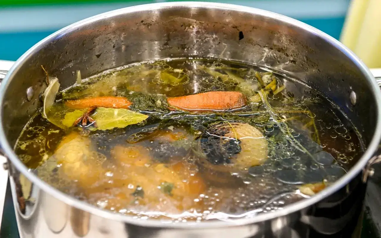 Bulion gotuje się w garnku z marchewką, cebulą i liściem laurowym. Liść laurowy w zupie nadaje głębi smaku i aromatu.