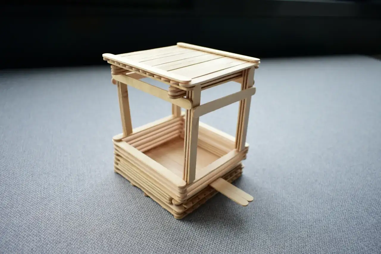 Miniaturowy karmnik dla ryb na staw, wykonany z patyczków. Prosty pomysł, jak zrobić karmnik dla ryb na staw.