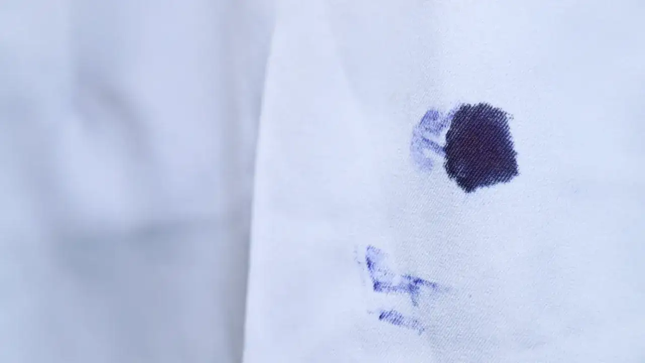 Plama z atramentu na białej tkaninie.