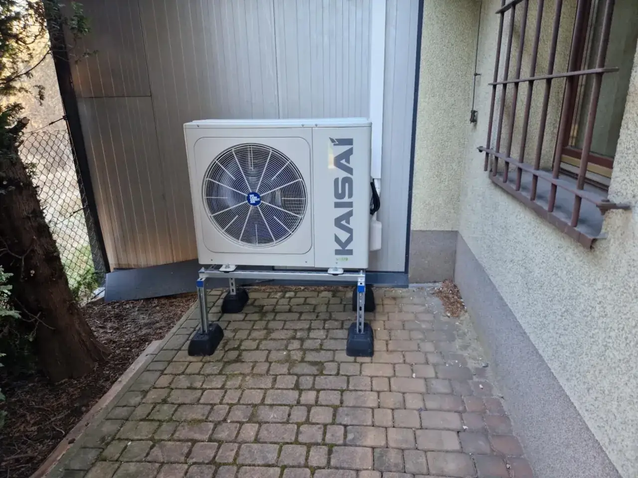 Jednostka zewnętrzna klimatyzatora KAISAI na wspornikach, gotowa do pracy w zmiennej temperaturze biwalentnej.