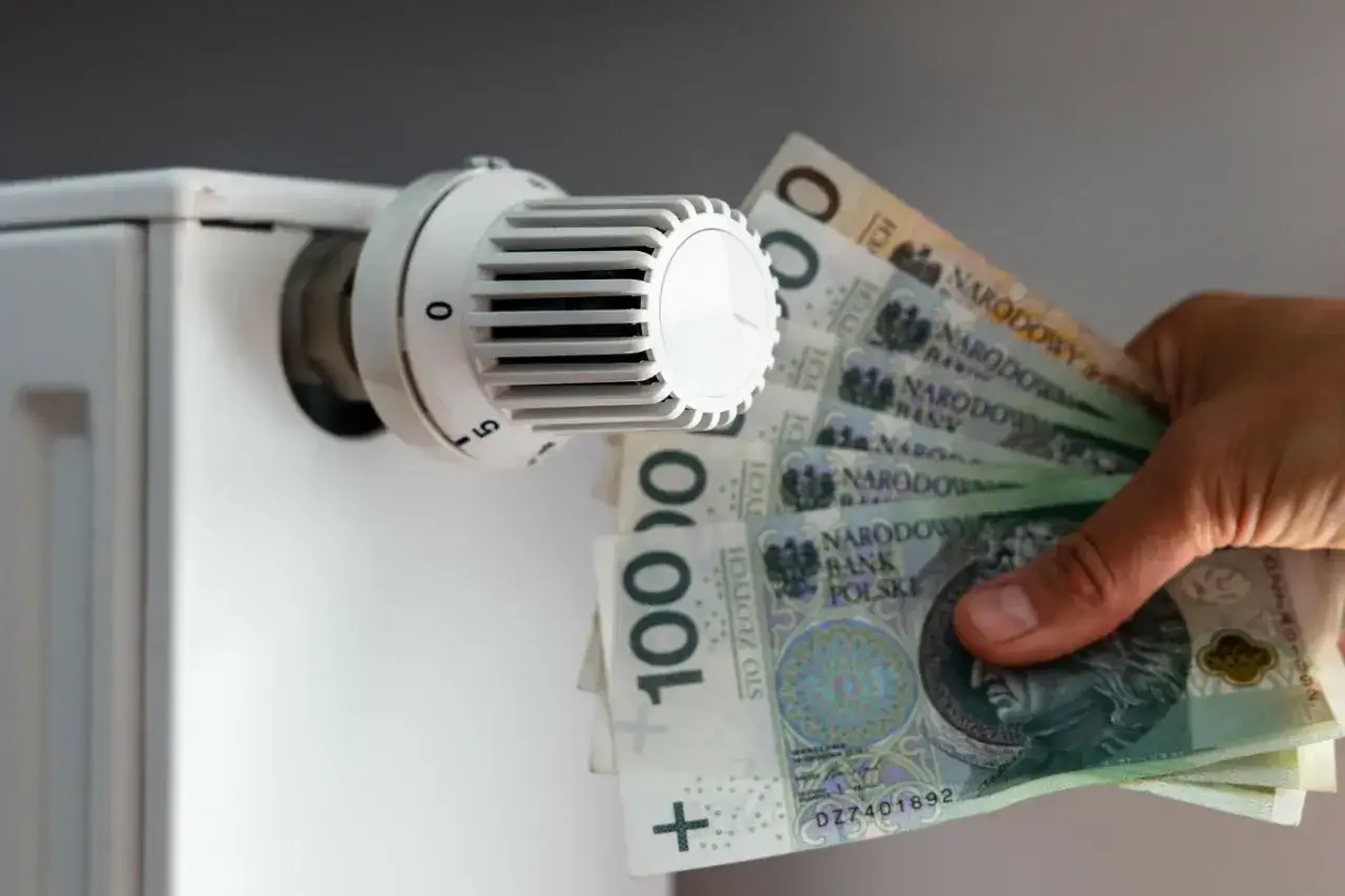 Dopłaty do prądu w postaci banknotów 100 zł przy termostacie grzejnika.