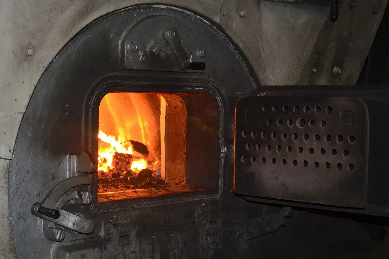 Piec węglowy w trakcie palenia. Wymiana pieca na wsi pomorskie to ważna inwestycja.