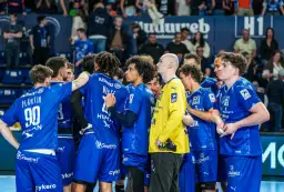 Drużyna Montpellier Handball w niebieskich strojach, skupiona przed meczem.