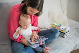 Mama z dzieckiem czyta książeczkę o samochodach. To idealny urlop na dziecko, pełen wspólnych chwil i nauki.