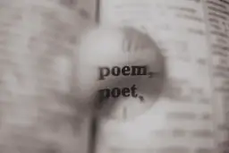 Zbliżenie na słowa "poem" i "poet" w książce pod lupą.
