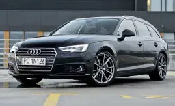 Czarny Audi A4 Avant z tablicą PO 1N126 na parkingu.