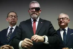 Trzech mężczyzn w garniturach. Lider z opaską na oku, zastanawia się, czy Konfederacja Korony Polskiej planuje samodzielny start w wyborach.