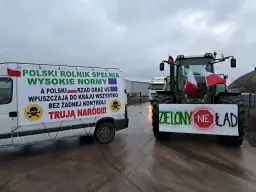 Ciężarówka i traktor z transparentami protestacyjnymi rolników.
