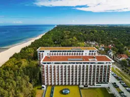 Pinea Resort Pobierowo, nowoczesne budynki hotelowe z widokiem na morze i las.