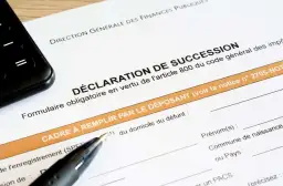 Un formulaire de déclaration de succession est prêt à être rempli, avec un stylo et un téléphone à proximité.
