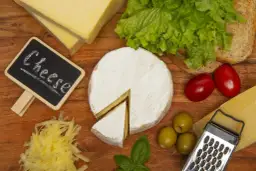 Deska serów: camembert, parmezan, żółty ser, oliwki, pomidorki, sałata i grzanka. Idealny ser na każdą okazję.