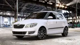 Biała Skoda Fabia z czarnymi felgami stoi w opuszczonej hali. Rozmiar opon idealnie pasuje do sportowego charakteru auta.
