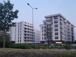 Nowoczesne bloki mieszkalne z balkonami na tle błękitnego nieba.