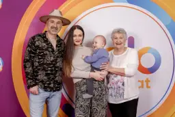 Mateusz Ziółko z rodziną: żoną, synkiem i mamą na tle kolorowego logo.