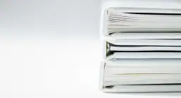 Stos białych ksiąg, jak regulamin porządku domowego, czeka na przeczytanie.