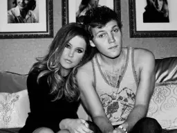 Lisa Marie Presley z synem Benjaminem Keough, siedzą blisko siebie na kanapie.
