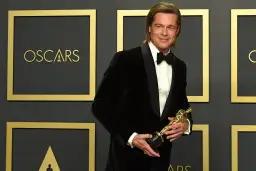 Brad Pitt z Oscarem w ręku, potwierdzając, czy Brad Pitt dostał Oscara.
