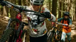 Kamera sportowa na kask rejestruje emocje z górskiej trasy. Kobieta z rowerem w lesie, gotowa na przygodę.
