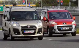 Złoty Fiat i czerwony Peugeot jadące po drodze.