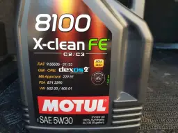 Czarna butelka oleju silnikowego Motul 8100 X-clean FE 5W30 z widocznymi specyfikacjami.