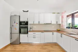 Jasny zlew doskonale komponuje się z drewnianym blatem w tej nowoczesnej kuchni.