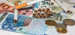 Papierosy i monety na banknotach euro. Zastanawiasz się, ile tytoniu można przewieźć do Niemiec?