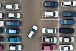 Widok z góry na parking. Samochody ustawione prostopadle przodem. Kiedy skręcać, by zaparkować?