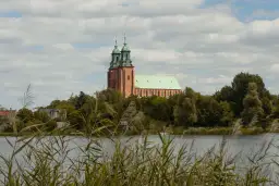 Majestatyczna katedra w Gnieźnie, jedna z głównych atrakcji miasta, góruje nad jeziorem.