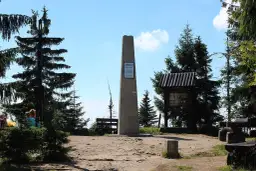 Na szczycie Turbacz, gdzie jest piękny widok, stoi obelisk. Wokół drzewa i ławki dla turystów.