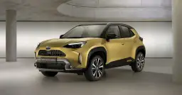 Złoty Toyota Yaris Cross 2025 Hybrid prezentuje się nowocześnie w studiu.