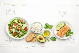 Zdrowa obiadokolacja: grillowany łosoś, sałatka z kurczakiem, twarożek, awokado i pieczywo.