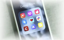 Smartphone-Bildschirm mit Icons verschiedener Dating-Apps wie Tinder, Badoo und Lovoo.
