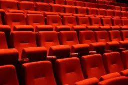 Puste czerwone fotele kinowe czekają na widzów. Czas na przerwę w teatrze, by napić się czegoś lub porozmawiać.