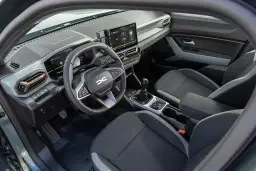 Wnętrze Dacia Duster: kierownica, ekran multimediów, dźwignia zmiany biegów i fotele.