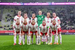 Reprezentacja Polski w piłce nożnej kobiet przed meczem z **Polska Słowenia**. Drużyna w białych strojach z orzełkiem na piersi.