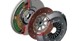 Rozłożony mechanizm sprzęgła: koło zamachowe, tarcza i docisk. Widać sprężyny i łożyska.