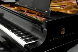 Czarne pianino Steinway & Sons z otwartą klapą, ukazującą struny i złote wnętrze. Zastanawiasz się, ile waży płyta mosiężna w pianinie?