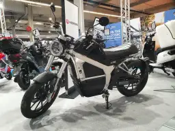 Elegancki motocykl elektryczny Horwin CR6, idealny do zdobycia prawa jazdy na motocykl. W tle inne skutery elektryczne.