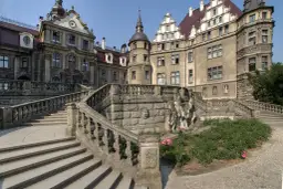 Kamienny zamek z wieżą i schodami. Warto zobaczyć, co to za moszna budowla!