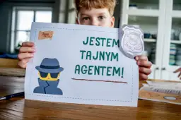 Chłopiec trzyma kartkę z napisem "Jestem tajnym agentem!" i rysunkiem szpiega. Idealne do gry szpiegowskie.