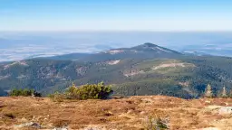 Widok z górnej części zbocza na zalesione pasma górskie i doliny. To najładniejszy szlak na Śnieżnik, z piękną panoramą.