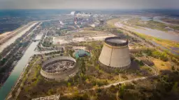 Opuszczone chłodnie kominowe elektrowni atomowej, które miały działać, gdy wybuchł Czarnobyl. W tle widać kompleks budynków i rzekę.